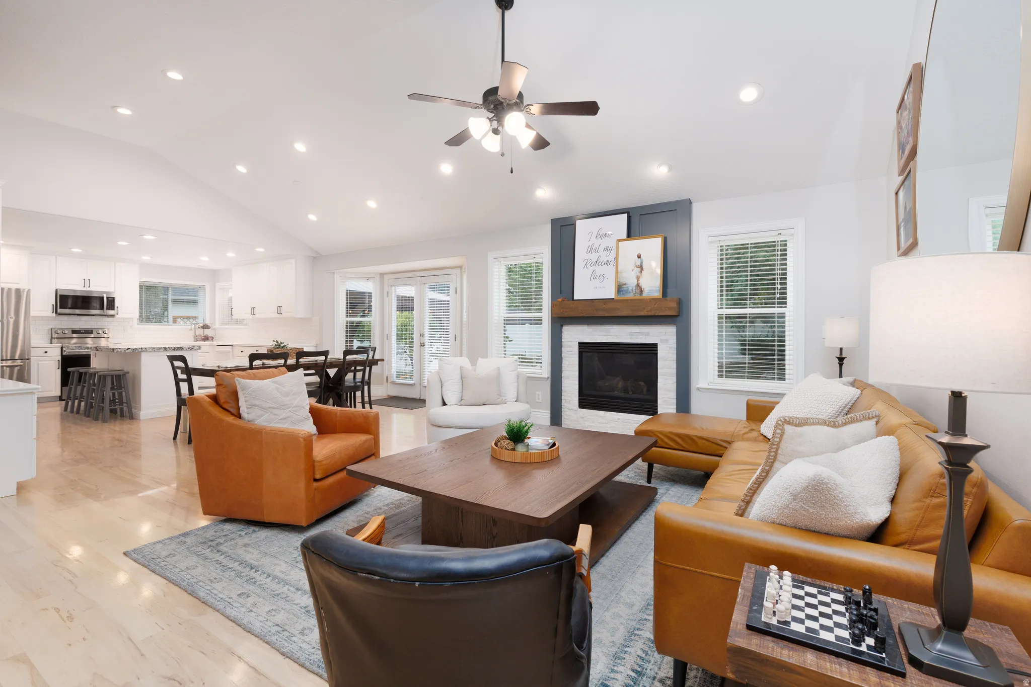 Spacious open-concept living area featuring vaulted ceilings, recessed lighting, and light wood-finish flooring