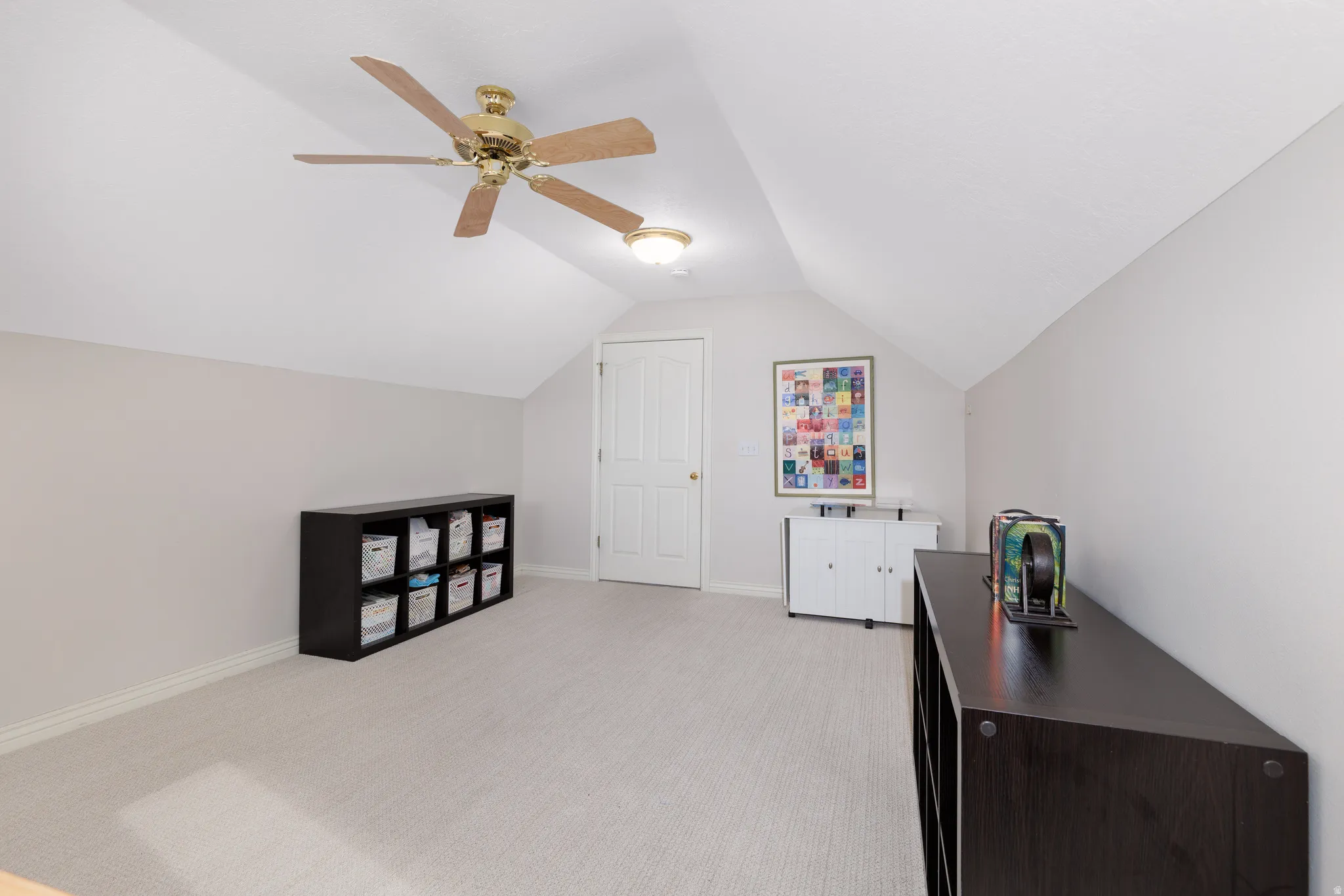 Carpeted room featuring a sloped ceiling and light neutral wall paint