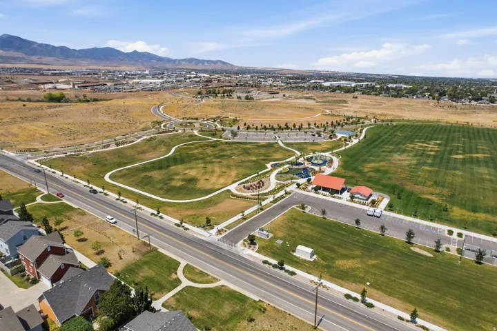 Expansive green spaces featuring walking paths, a playground area, and recreational facilities