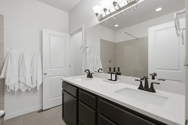 Dual vanity featuring integrated rectangular sinks, dark cabinetry, and matte black faucets