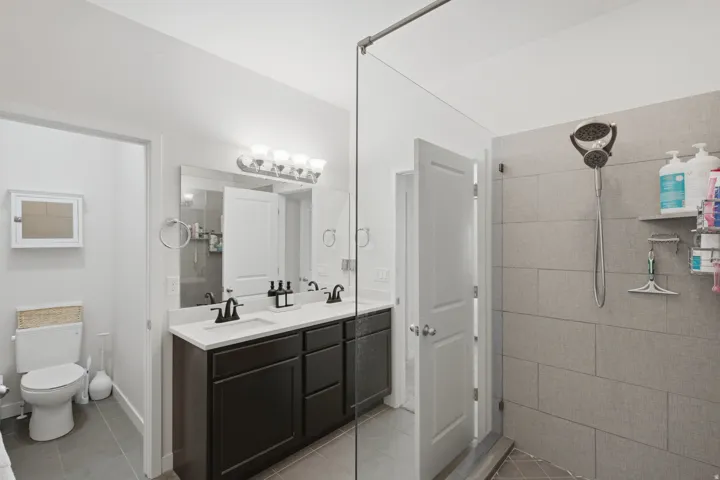 Double vanity with black cabinetry, white countertops, and matte black fixtures