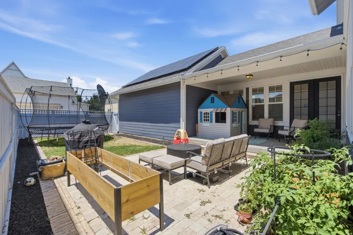 Covered patio featuring string lighting, paver flooring, and dual French doors