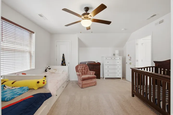 Bedroom featuring neutral carpet flooring, white walls, and a ceiling fan with light fixture