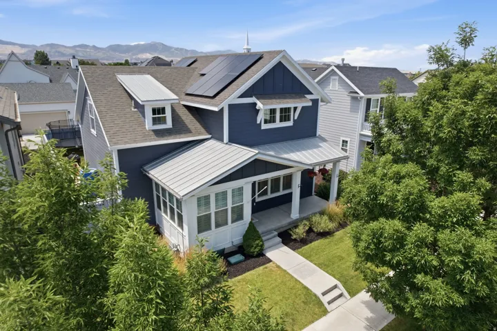 Two-story residence featuring a dark blue siding exterior with white trim accents and a contrasting gray shingle roof