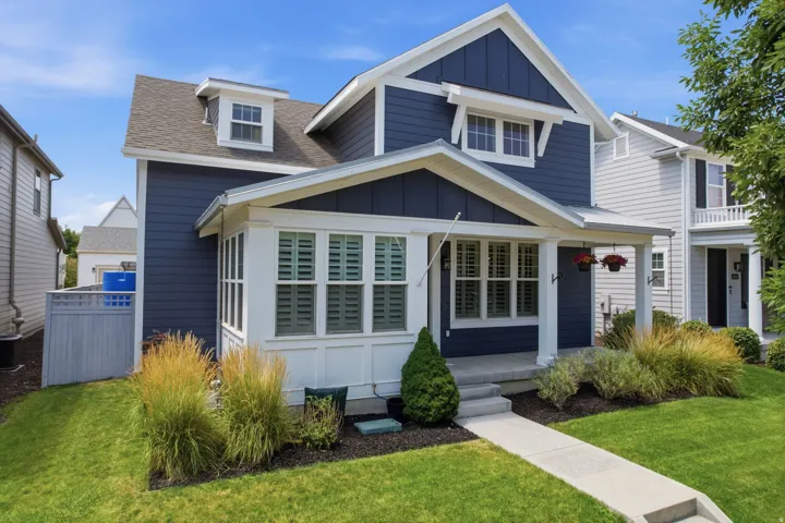 Two-story residence featuring a dark blue siding facade, white trim, and a prominent front porch with white columns