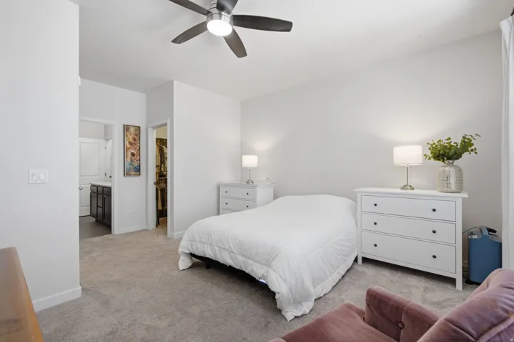 Well-lit room featuring light-colored walls and carpet flooring