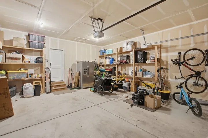 Spacious garage featuring concrete flooring and exposed ceiling beams