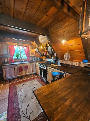 Rustic updated kitchen featuring newer stainless steel gas range & fridge! Newer countertops & cabinets!