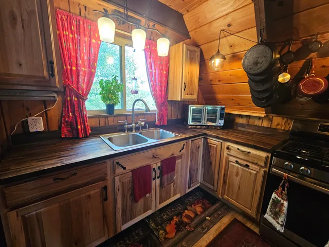 Rustic updated kitchen featuring newer stainless steel gas range & fridge! Newer countertops & cabinets!