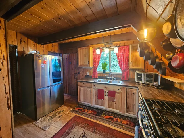 Rustic updated kitchen featuring newer stainless steel gas range & fridge! Newer countertops & cabinets!