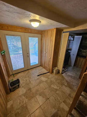 Basement entryway featuring double French doors leading to nice patio with tile floors!