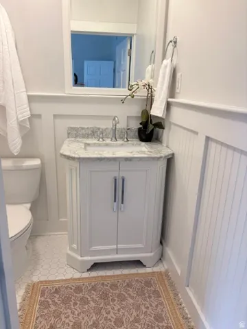 White vanity with a stone countertop and undermount sink