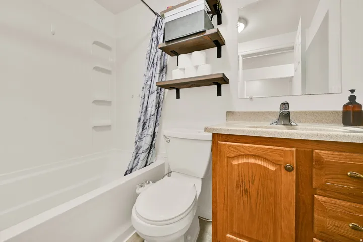 Bathroom vanity with wood cabinetry, a light-toned countertop, and a basin sink