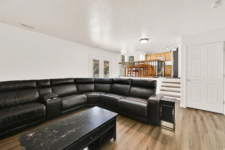 Split-level interior featuring wood-finish flooring, white walls, and a recessed kitchen with wood cabinetry