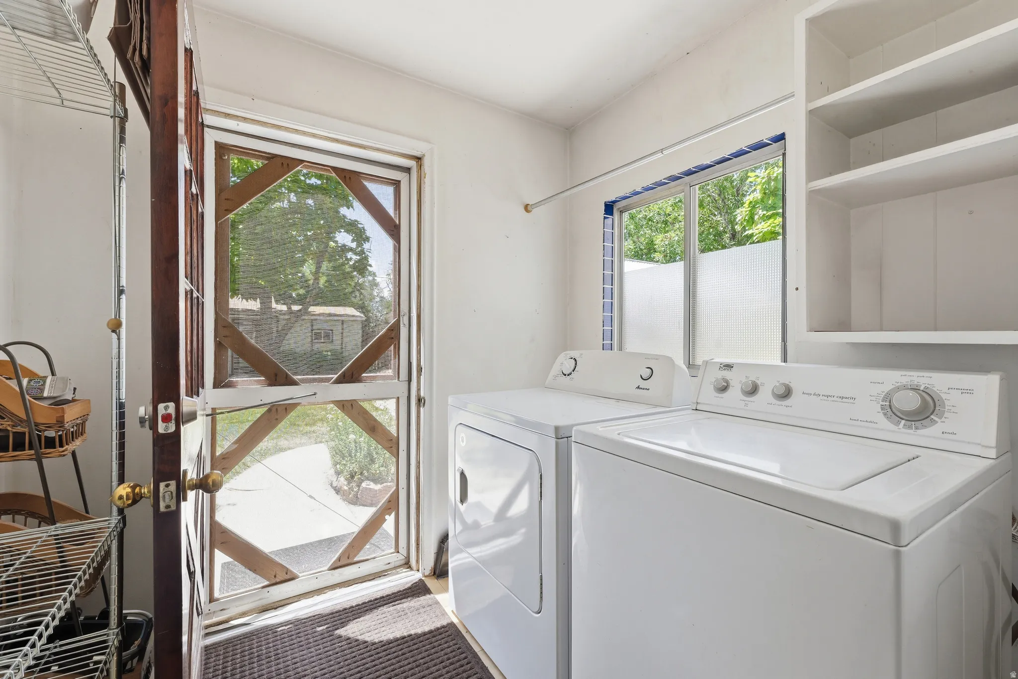Dedicated laundry area featuring a white top-load washer and front-load dryer