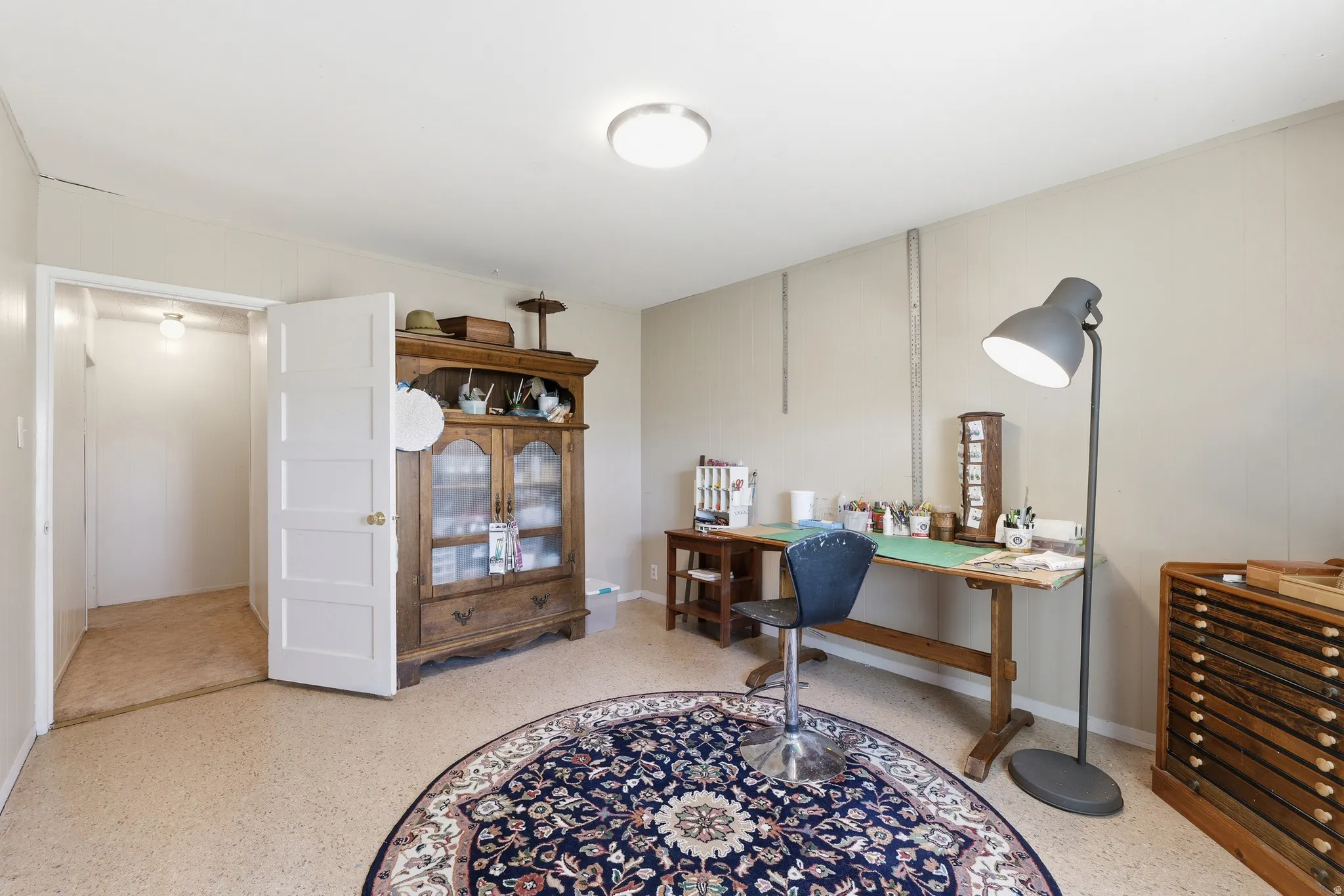 Versatile room featuring light-toned walls and speckled flooring