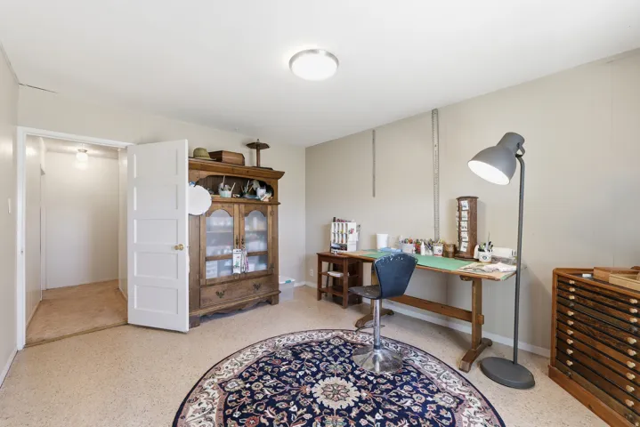 Versatile room featuring light-toned walls and speckled flooring