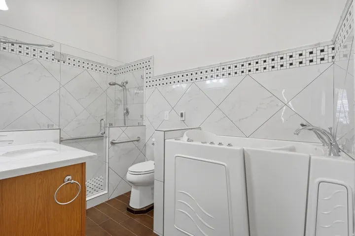 Bathroom featuring a walk-in tub and a separate glass-enclosed shower