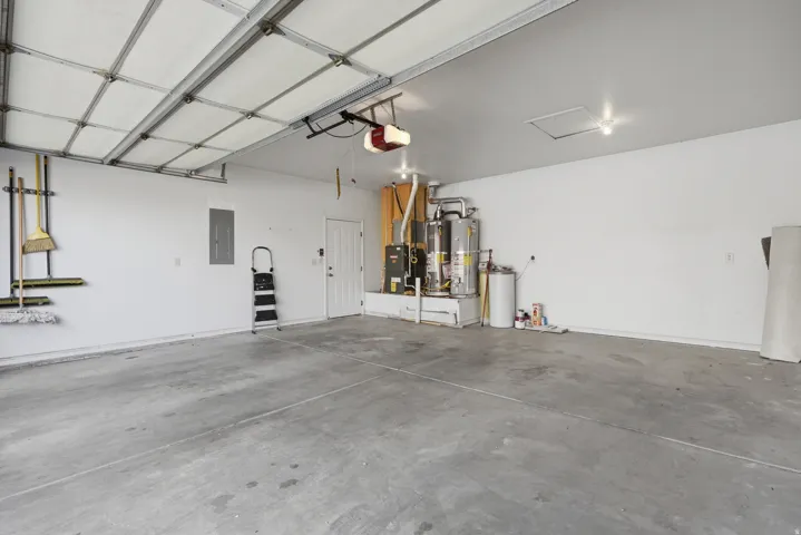 Spacious garage featuring a concrete floor, white painted walls, and an overhead garage door