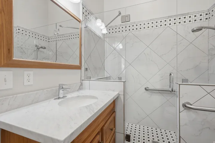 Bathroom featuring a wood vanity with a white countertop and integrated sink