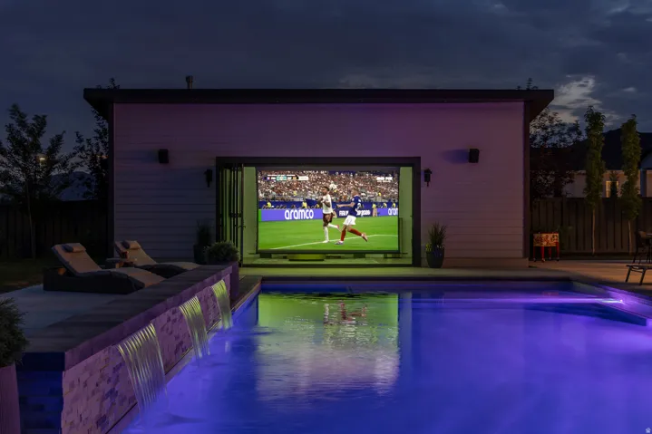 Outdoor entertainment pavilion with a large screen display and bi-fold doors