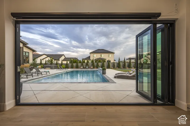 Expansive multi-panel folding glass doors opening to a large outdoor pool area