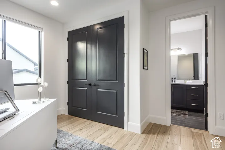 Double panel doors with matte black hardware, wood-finish flooring, and crisp white baseboards