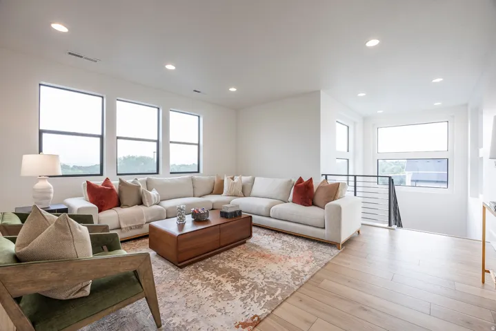 Open-concept living area featuring light wood-finish flooring, recessed lighting, and expansive windows