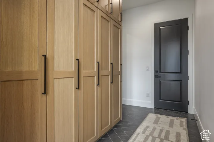 Custom built-in wood cabinetry with matte black hardware, complementing the dark-paneled interior door
