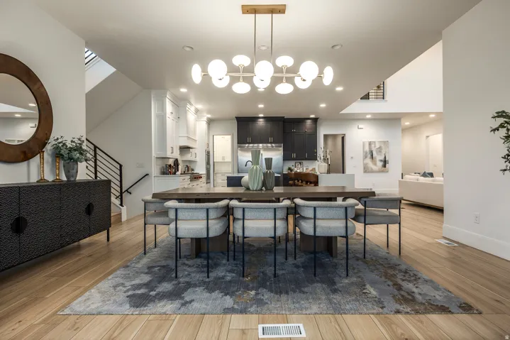 Spacious dining area featuring wood-finish flooring and a contemporary chandelier