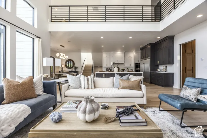 Open concept living area featuring a two-story ceiling and abundant natural light from large windows