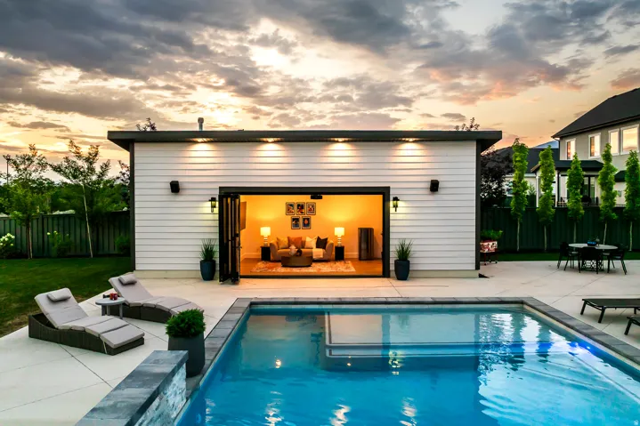 In-ground swimming pool with stone coping and integrated lighting