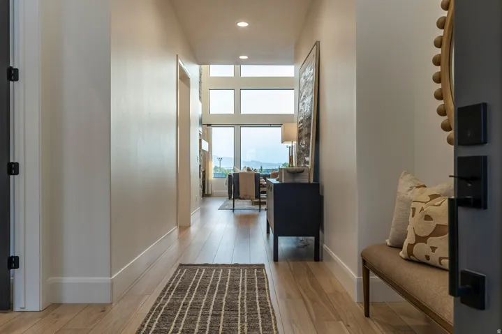 Bright hallway with light wood-finish flooring extending into the main living area