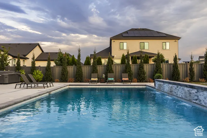 Rectangular inground swimming pool with a stone-clad waterfall feature