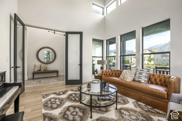 Living space with high ceilings and light wood-finish flooring