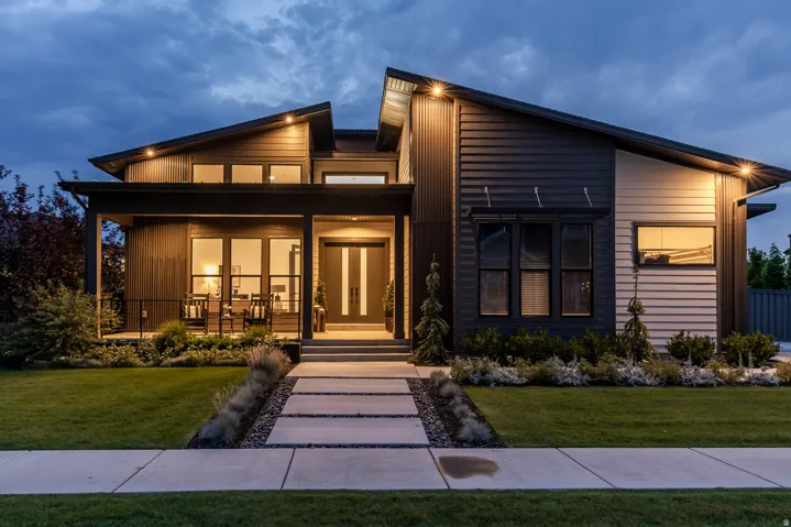 Modern architectural design with a multi-textured exterior, prominent front entryway, and an inviting covered porch
