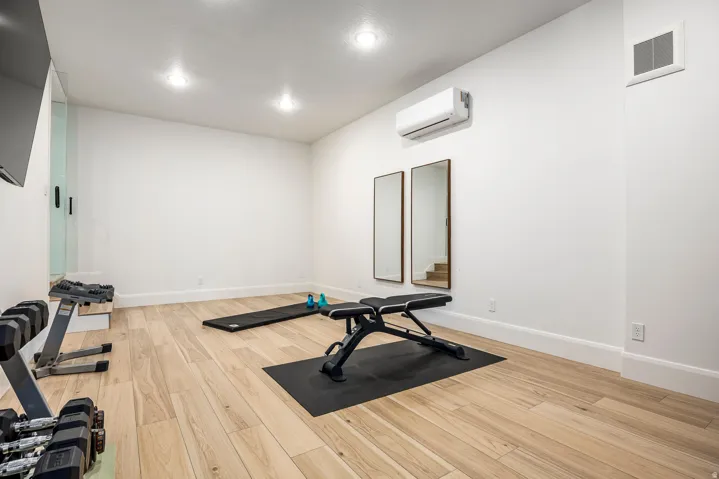 Spacious room featuring light wood-finish flooring, recessed lighting, and white walls with thick baseboards