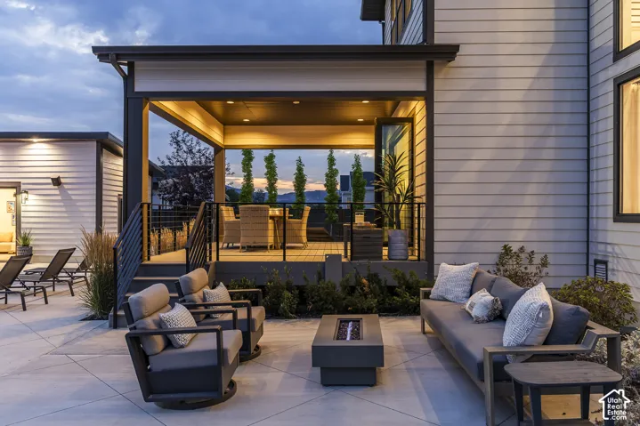 Expansive concrete patio featuring a built-in fire pit