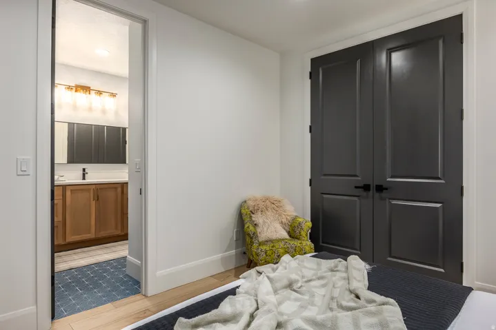 Bedroom featuring engineered hardwood flooring and dual panel doors with matte black hardware