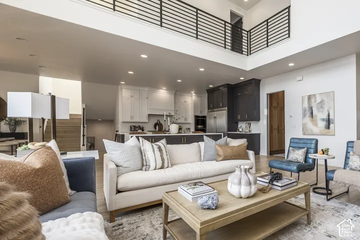 Open-concept living area featuring high ceilings, recessed lighting, and wood-finish flooring