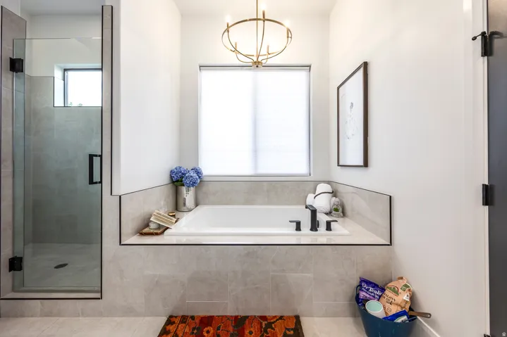 Built-in soaking tub with matte black fixtures, set within a tiled surround