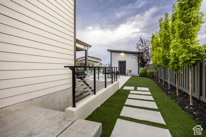 Manicured artificial turf lawn with concrete paver pathway