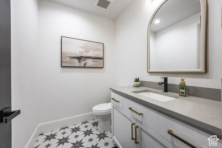 Contemporary vanity featuring a rectangular undermount sink, a matte black faucet, and brass hardware