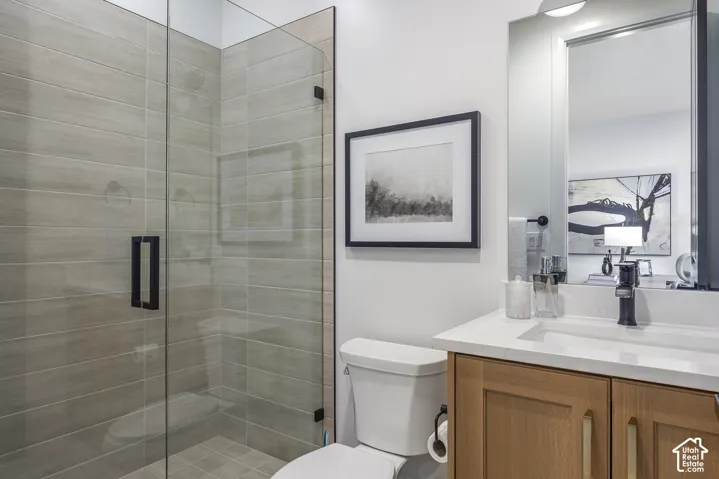 Glass-enclosed shower with horizontal tile surround and matte black hardware