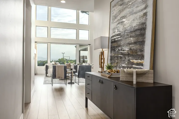 Expansive living area featuring a wall of floor-to-ceiling windows, wood-finish flooring, and recessed lighting