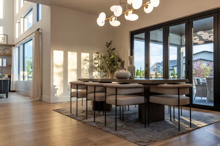 Open concept interior with wood-finish flooring, a contemporary chandelier, and expansive windows