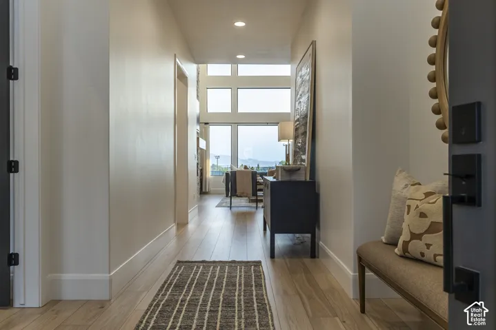 Bright hallway with light wood-finish flooring extending into the main living area