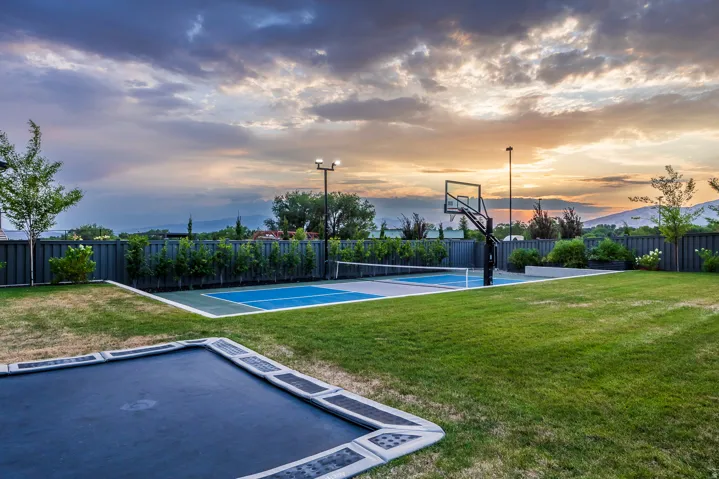 Manicured lawn area featuring an in-ground trampoline