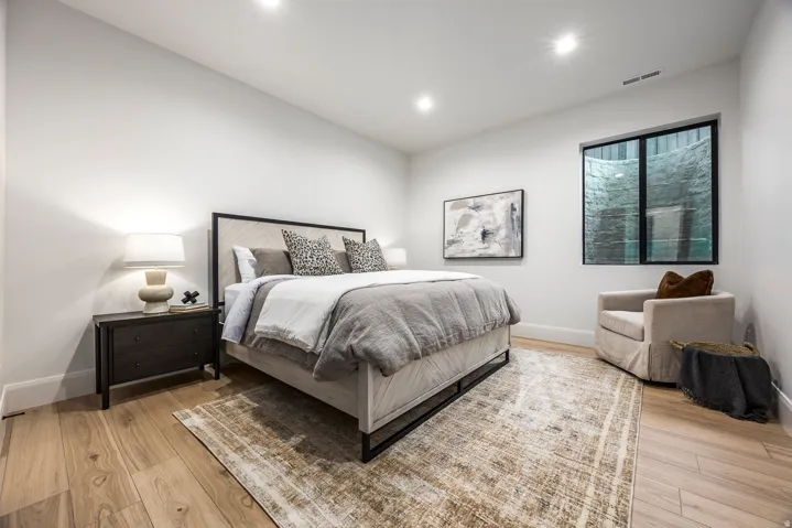 Spacious room featuring wood-finish flooring, recessed lighting, and a contemporary window with a black frame