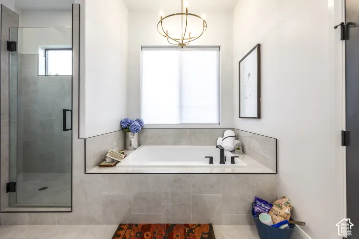 Built-in soaking tub with matte black fixtures, set within a tiled surround